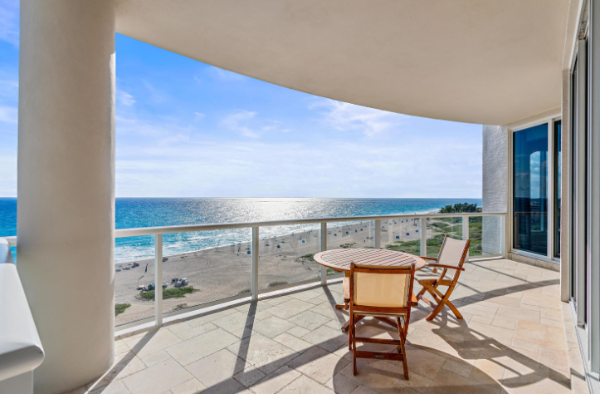 The expansive balcony of a Singer Island condo with an ocean view on a sunny day
